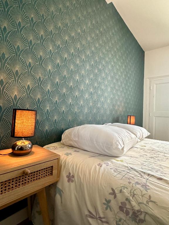 une chambre avec un lit et une table avec une lampe dans l'établissement Appartement Minervoise - Gare Carcassonne, à Carcassonne