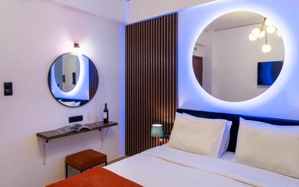 a bedroom with a bed and a round mirror at Dema Luxury Suites - Romvis in Athens
