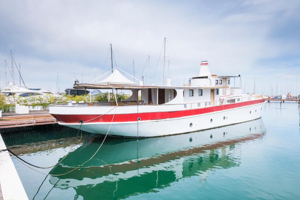 een rode en witte boot aangemeerd bij een dok bij Nave Contessa in Rimini