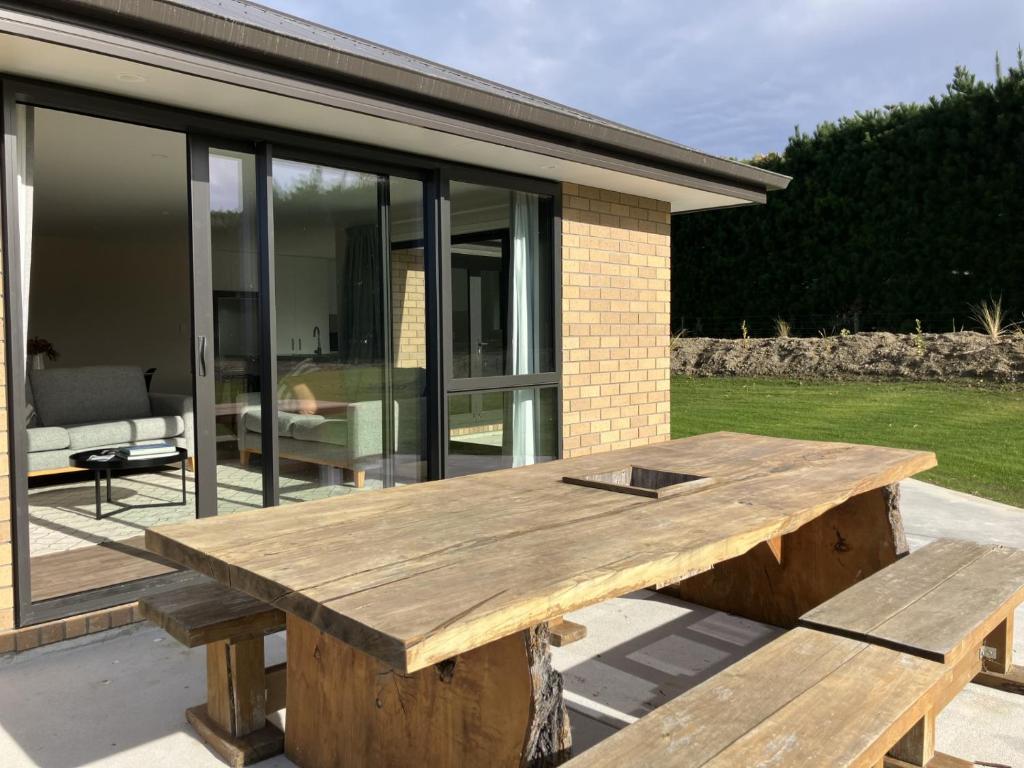 a wooden picnic table in front of a house at 3-Bedroom Retreat in Mount Somers in Mount Somers