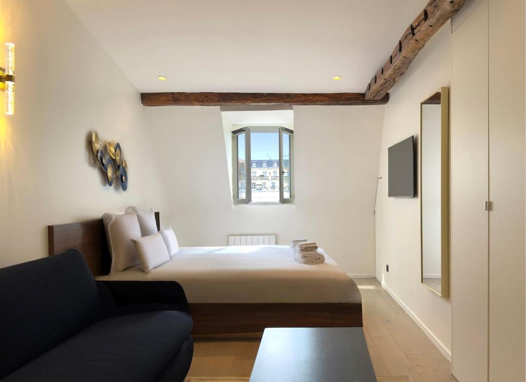 une petite chambre avec un lit et un canapé dans l'établissement Luxury Suite, Montaigne & Champs Elysées, à Paris