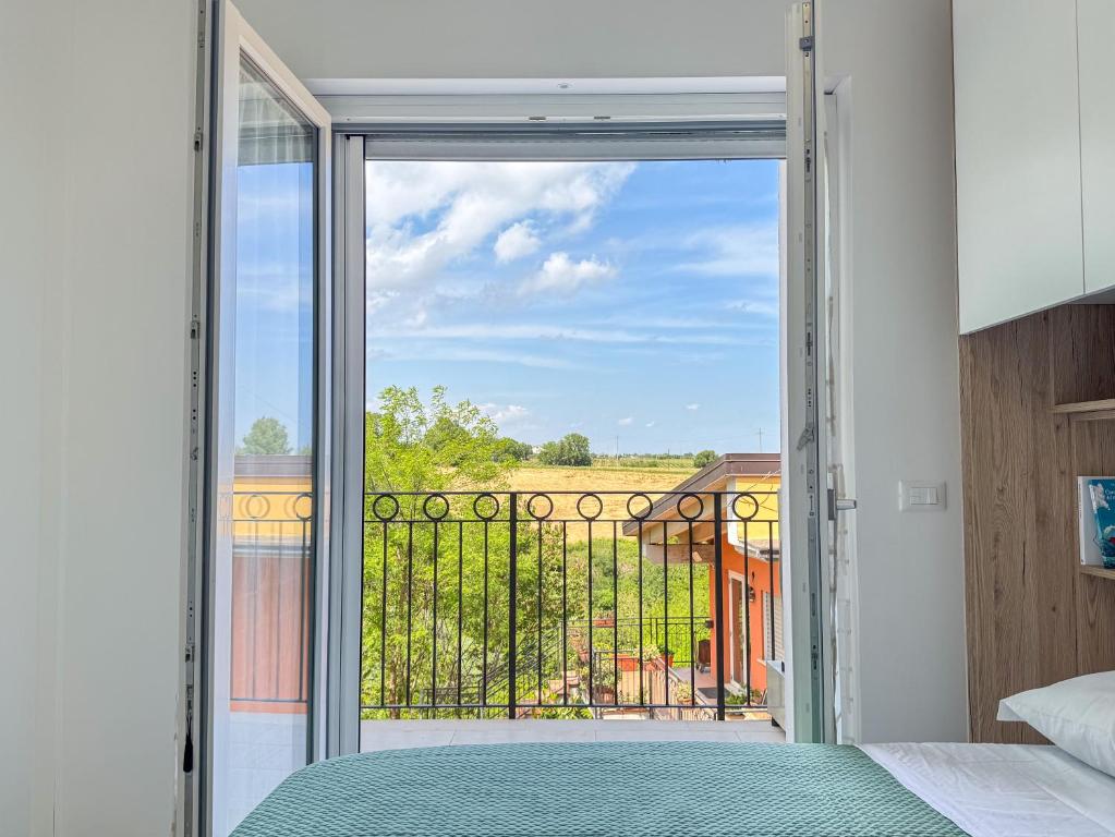 sypialnia z drzwiami wychodzącymi na balkon w obiekcie La Dimora del Borgo - Appartamento La Torre w mieście Rocca San Giovanni