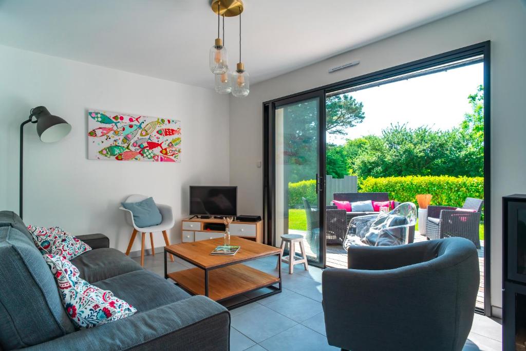 un salon avec un canapé, des chaises et une télévision dans l'établissement Parenthèse Iodée - 7min à Pied de la Plage, à Bénodet