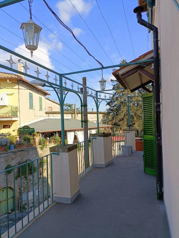 a walkway with green gates and a fence at La terrazza sul Borgo di Quadroni in Manziana