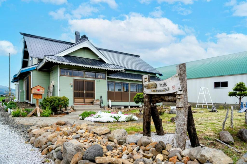 a house with a sign in front of it at ラベンダー畑まで5分ー最大10人ーお餅つきー流しそうめんー花火ー五右衛門風呂ー心と身体が元気になる古民家民泊ーオモテナシロッジ悠遊 in Nakafurano