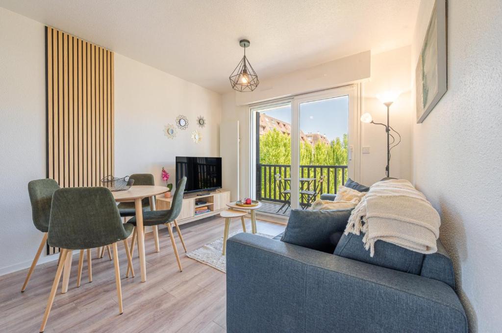 un salon avec un canapé bleu et une table dans l'établissement L'Opaline - F2 pour 4Pers / Houlgate, à Houlgate