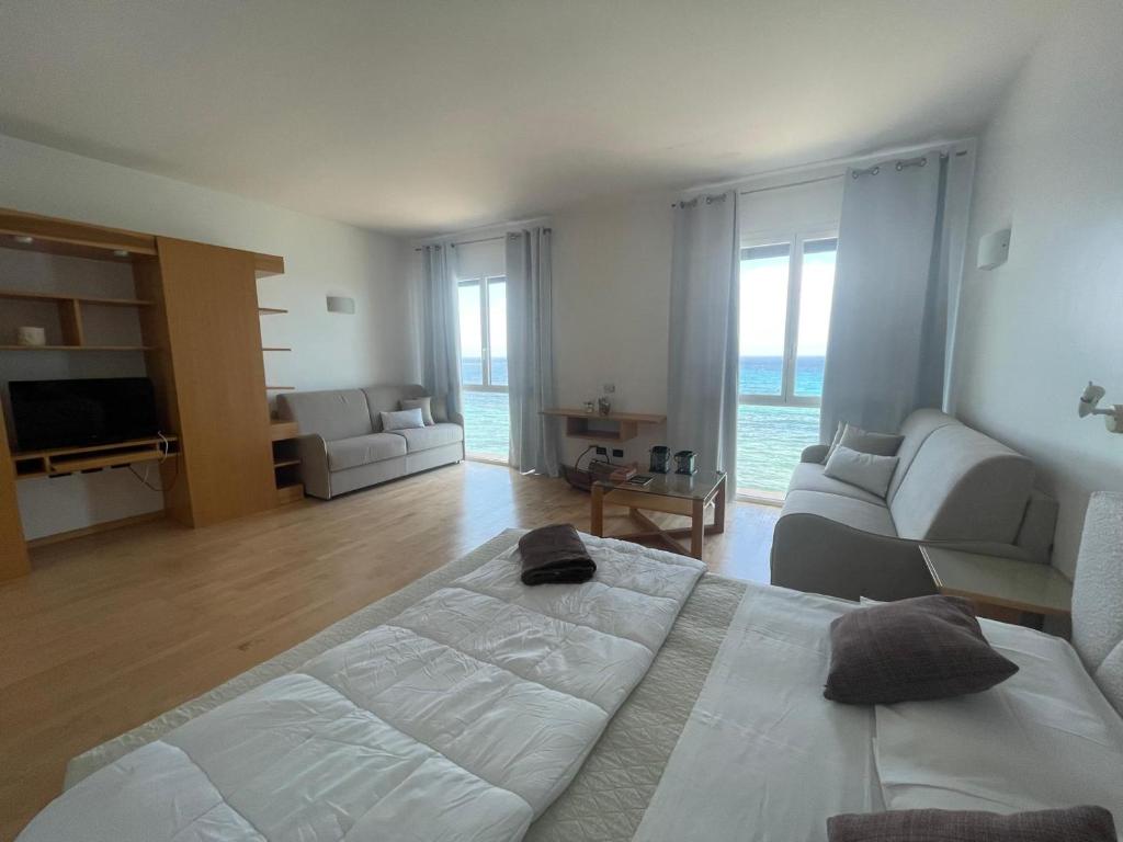 una camera da letto con un letto grande e un soggiorno di Garibaldi Sea Suites a Trapani