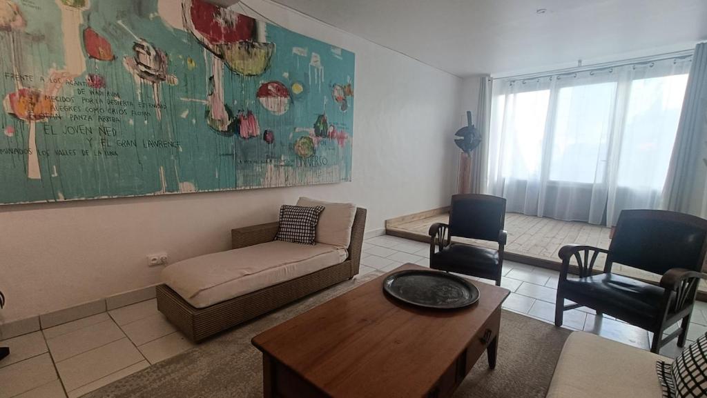 a living room with a couch and a table and chairs at Chez Marie, maison ArtY in Lauzun