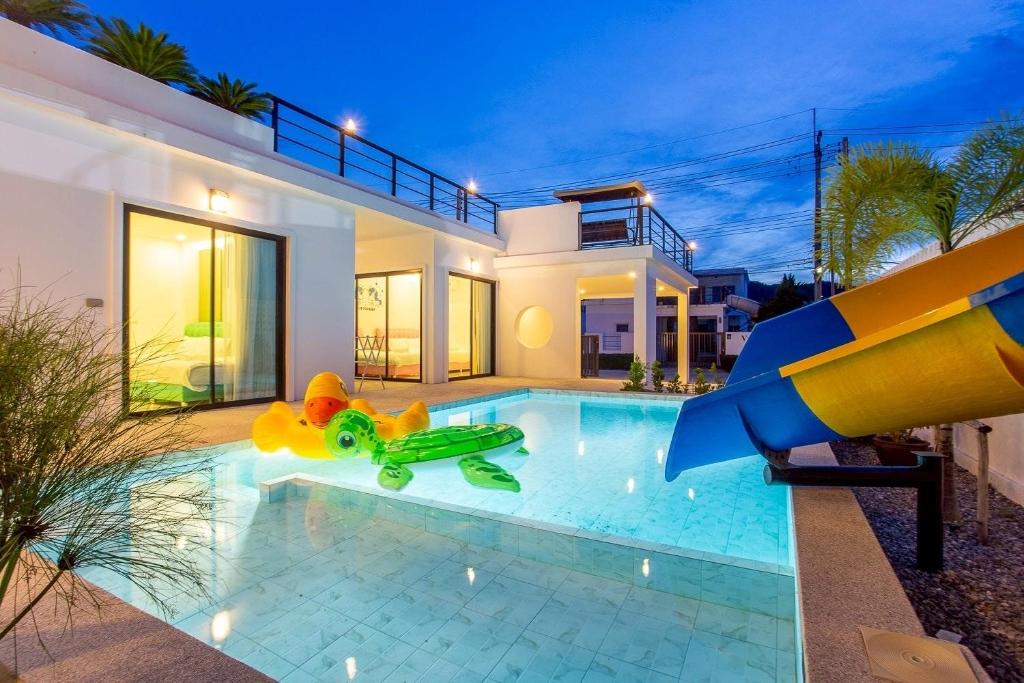 a house with a swimming pool with a slide at Happy Time Pool Villa in Ban Nong Chaeng