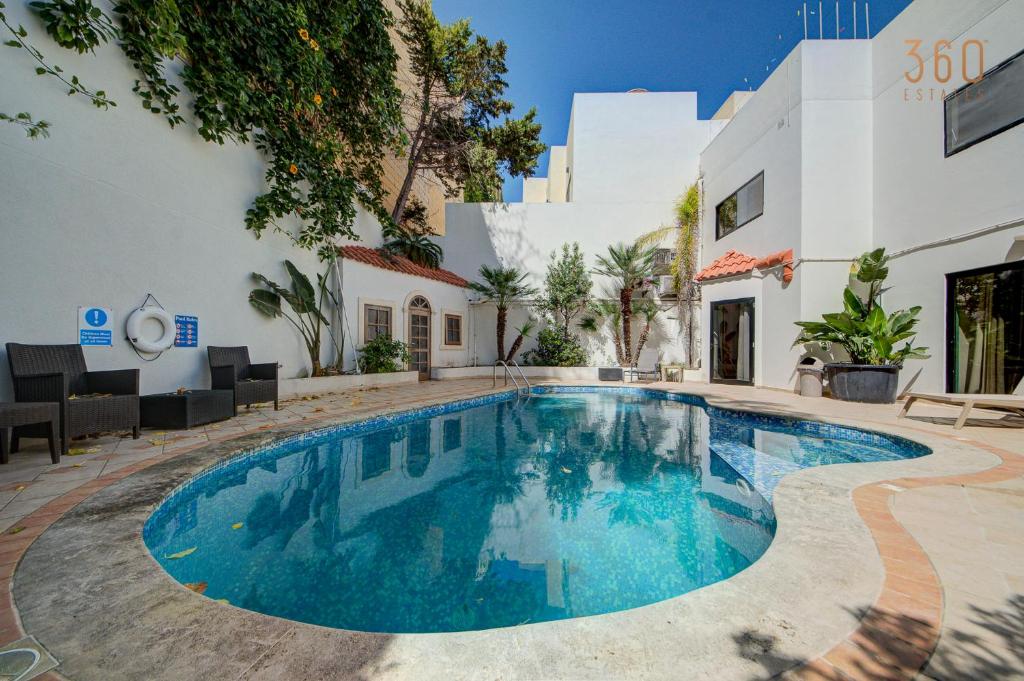 a swimming pool in front of a building at Bungalow home with Stunning Pool Area in St'Julians By 360 Estates in St Julian's