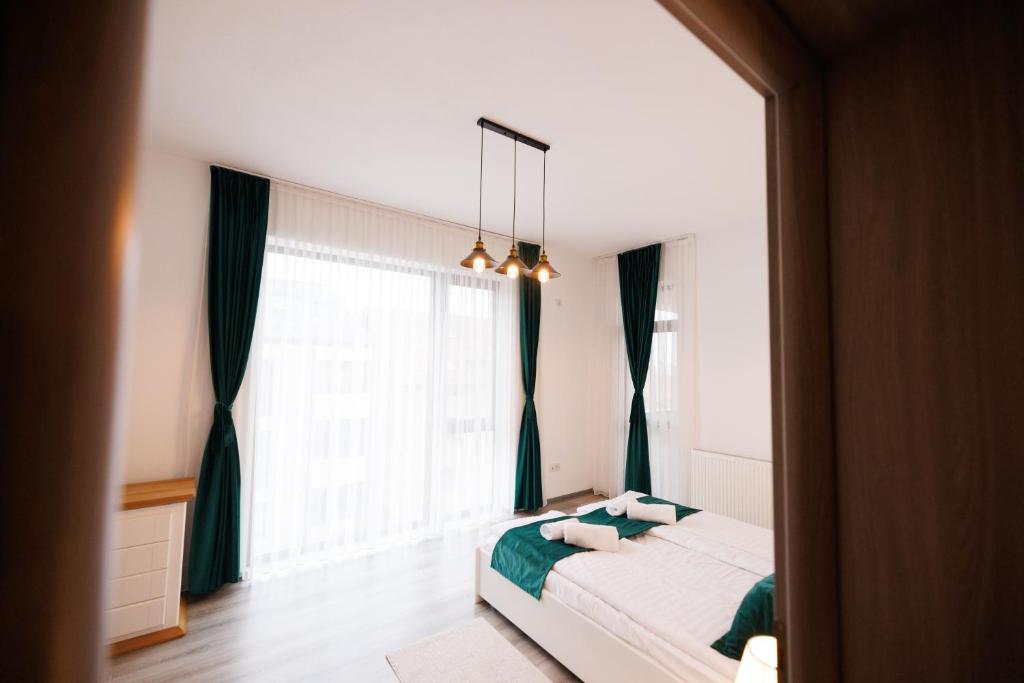 a bedroom with a bed and a large window at Thyon Apartments in Sebeş