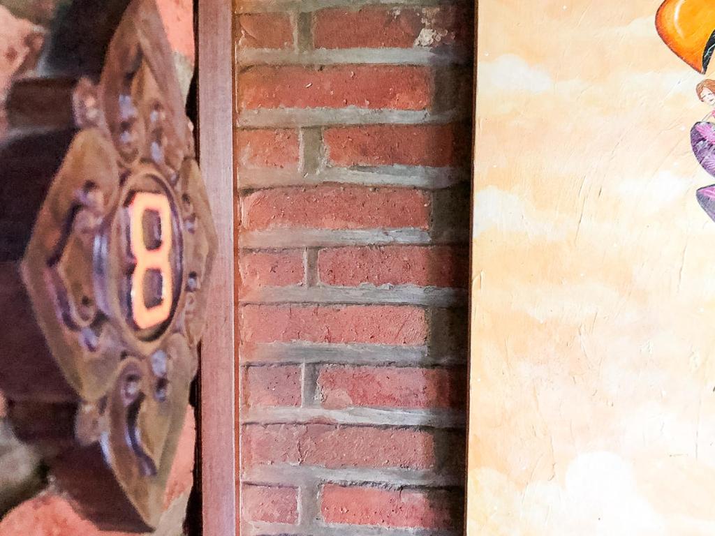 a door with a metal object on a brick wall at Arys Garden Hotel Yogyakarta in Yogyakarta