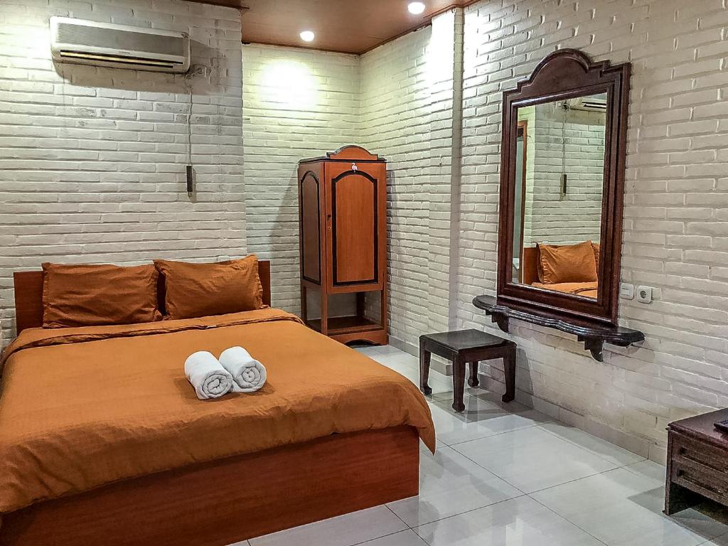 a bedroom with a bed with two towels on it at Arys Garden Hotel Yogyakarta in Yogyakarta