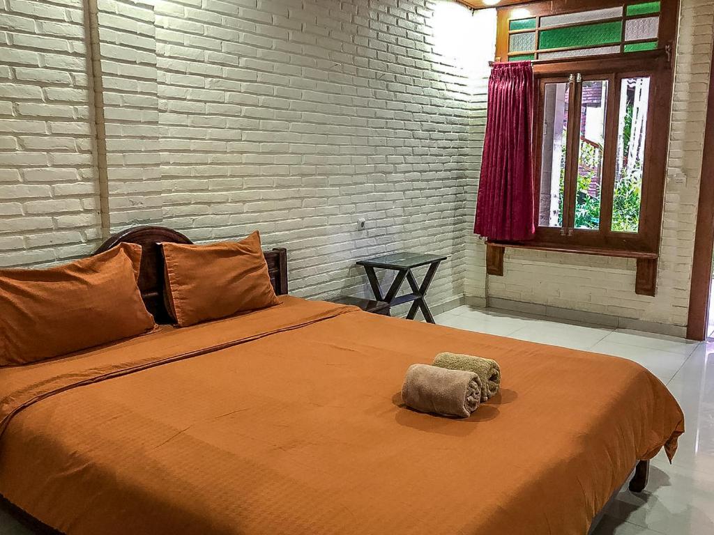 a bed with two pillows on it in a bedroom at Arys Garden Hotel Yogyakarta in Yogyakarta