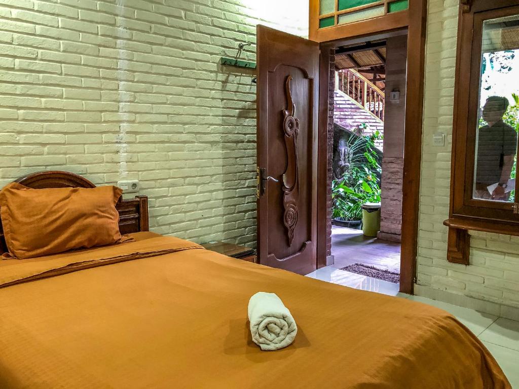 a bedroom with a bed with a towel on it at Arys Garden Hotel Yogyakarta in Yogyakarta