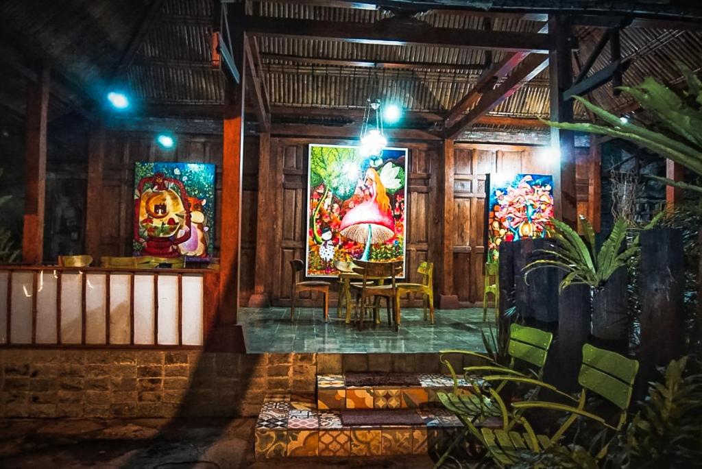 a room with paintings on the walls of a building at Arys Garden Hotel Yogyakarta in Yogyakarta