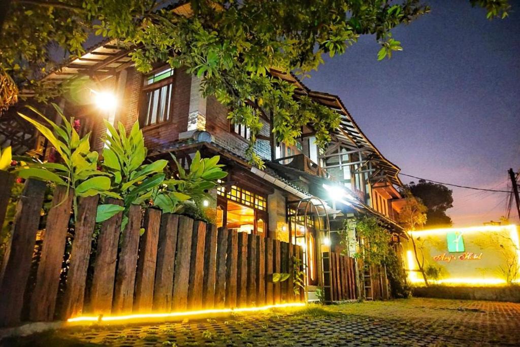 an old house with a wooden fence at night at Arys Garden Hotel Yogyakarta in Yogyakarta