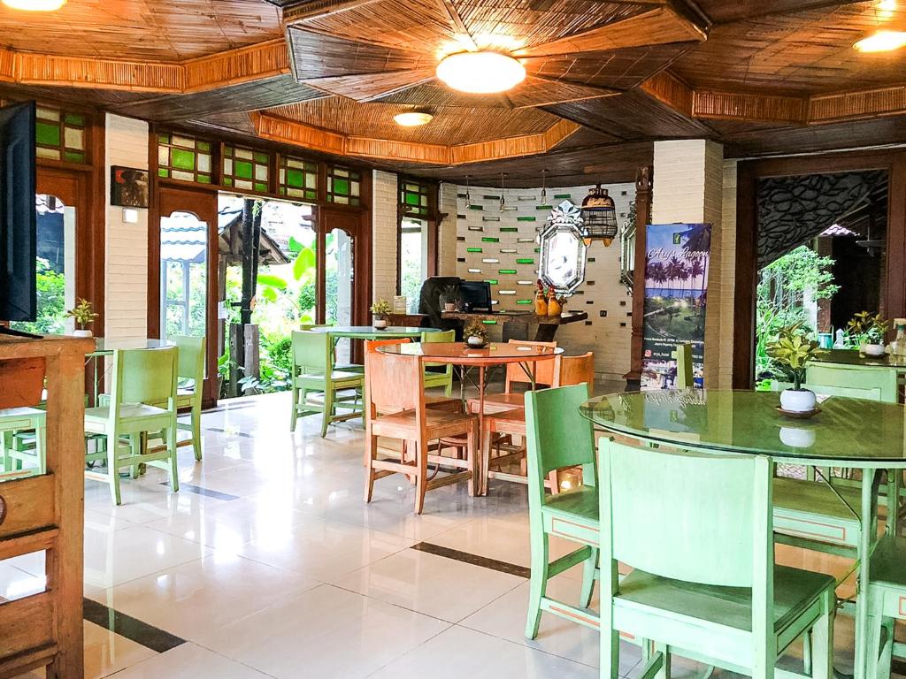 a dining room with a table and chairs at Arys Garden Hotel Yogyakarta in Yogyakarta