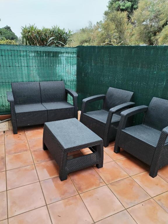 un groupe de chaises et une table sur une terrasse dans l'établissement Maison de vacances à Torreilles, à Torreilles