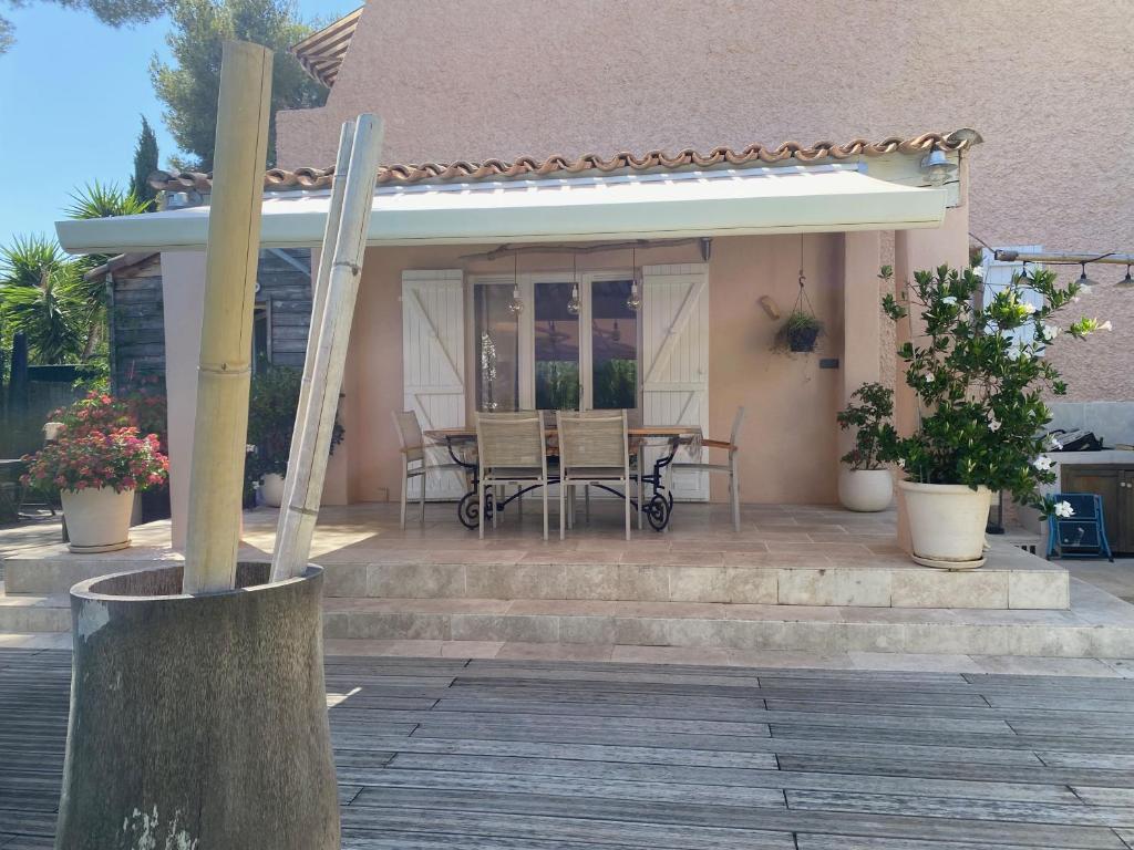 une terrasse couverte d'une maison avec une table et des chaises dans l'établissement studio avec grand jardin, à La Ciotat
