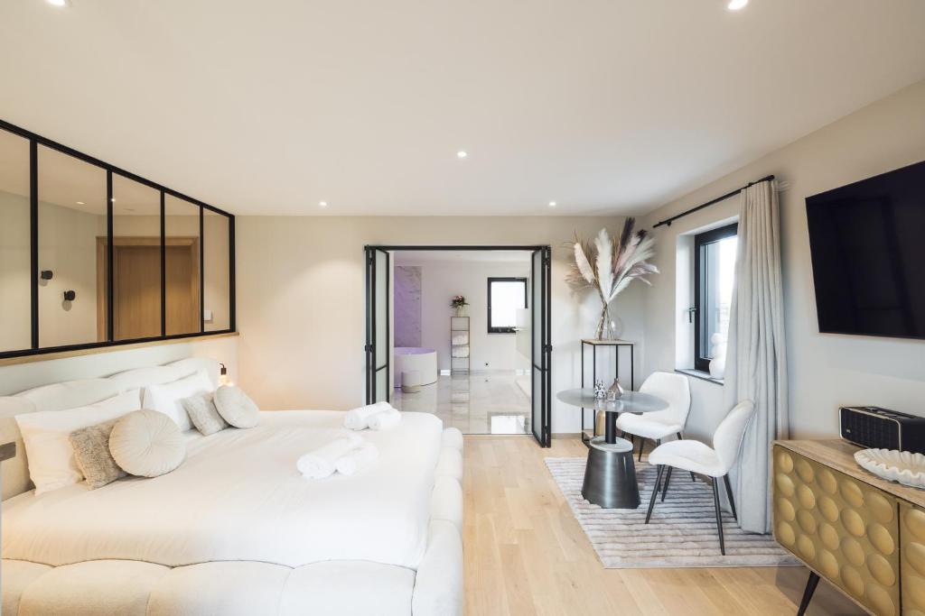 a bedroom with a white bed and a living room at Suite Cocoon By M in Francorchamps