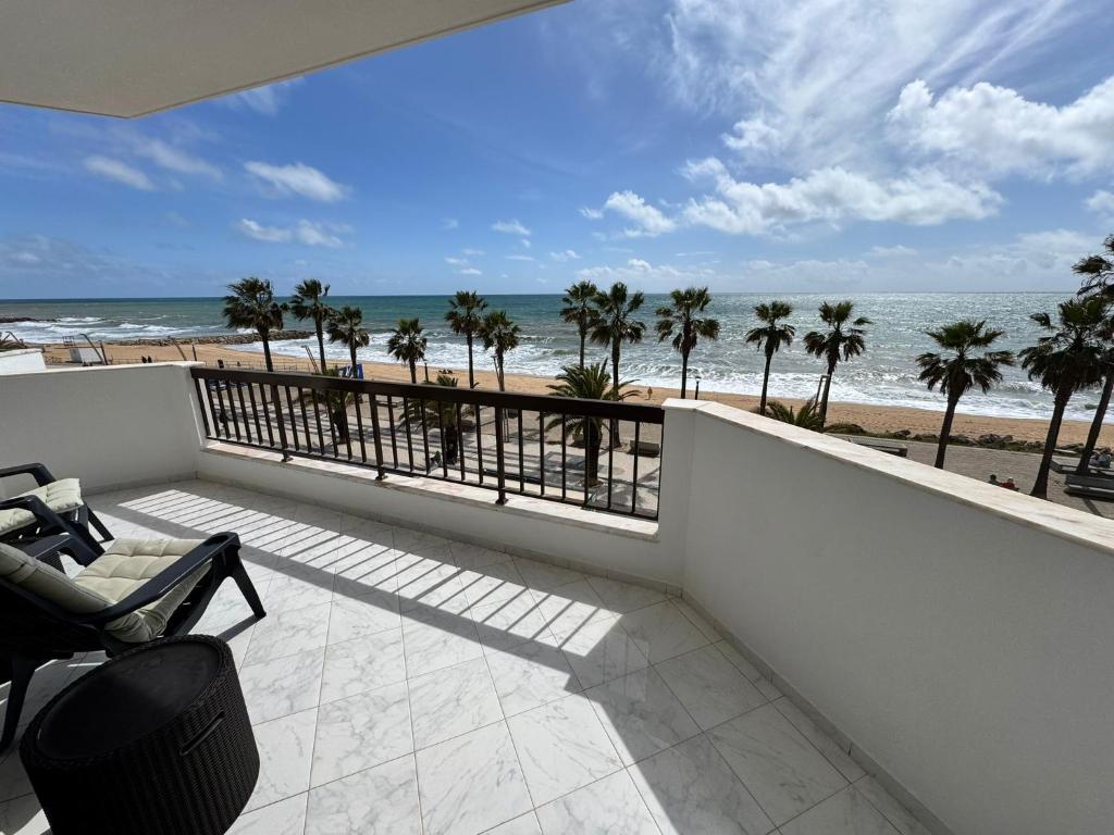 a balcony with a view of the beach at Beachfront Sea View 2BR Apartment in a prime location in Quarteira