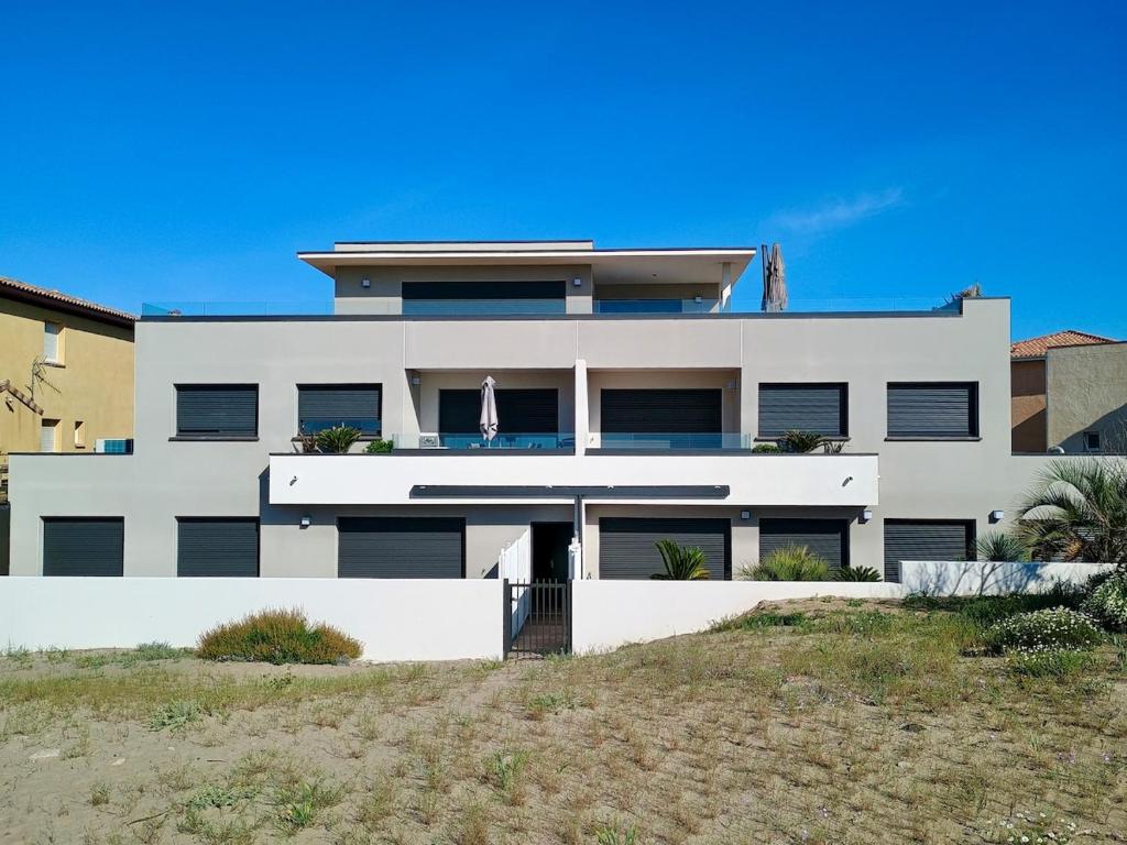 une grande maison blanche sur la plage dans l'établissement AYAPI - Appartement neuf 3 étoiles avec terrasse et jardin - bord de plage, à Marseillan