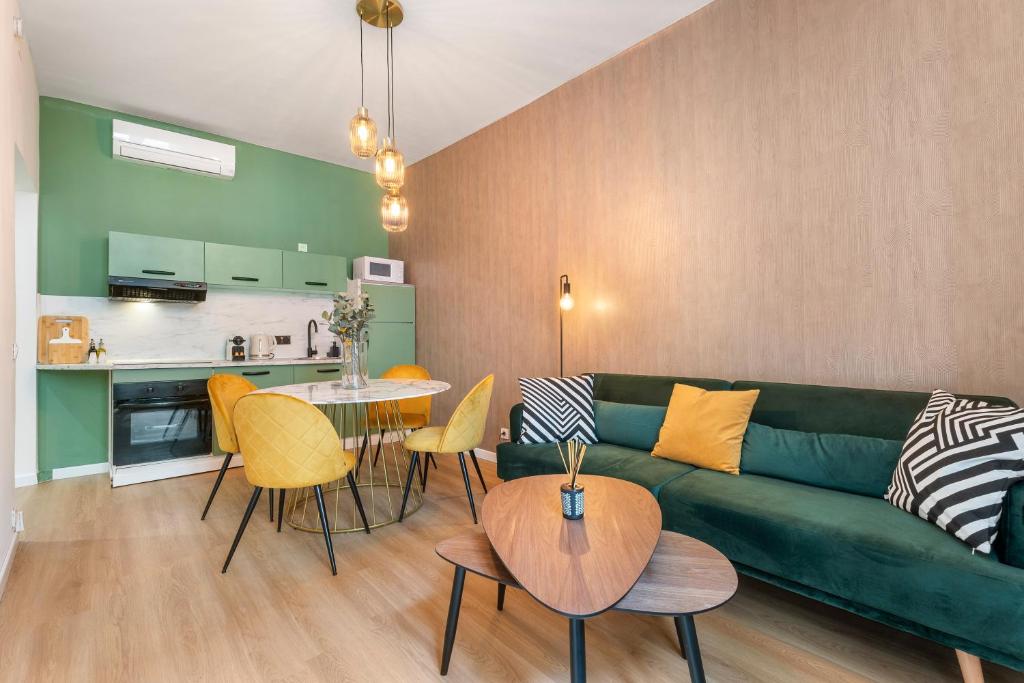 un salon avec un canapé vert et une table dans l'établissement 2P architecte Hyper-centre, à Nice