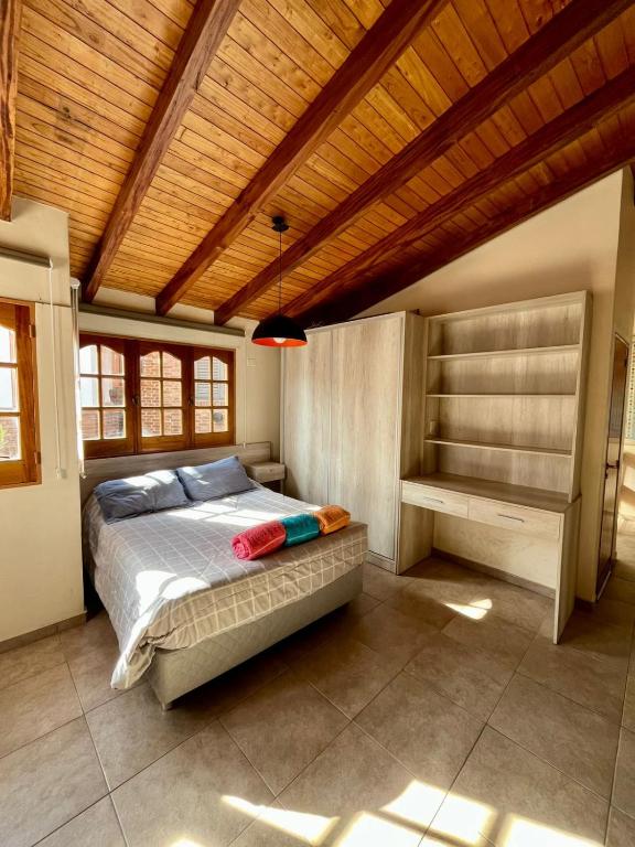 a bedroom with a bed and a wooden ceiling at Amplio departamento monoambiente a metros del parque general San Martín in Mendoza