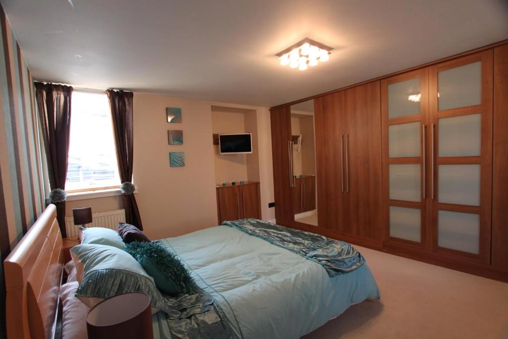 a bedroom with a large bed and a window at Nairnia in Nairn