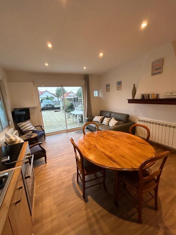 un salon avec une table en bois et un canapé dans l'établissement Maison Algus, à Cucq