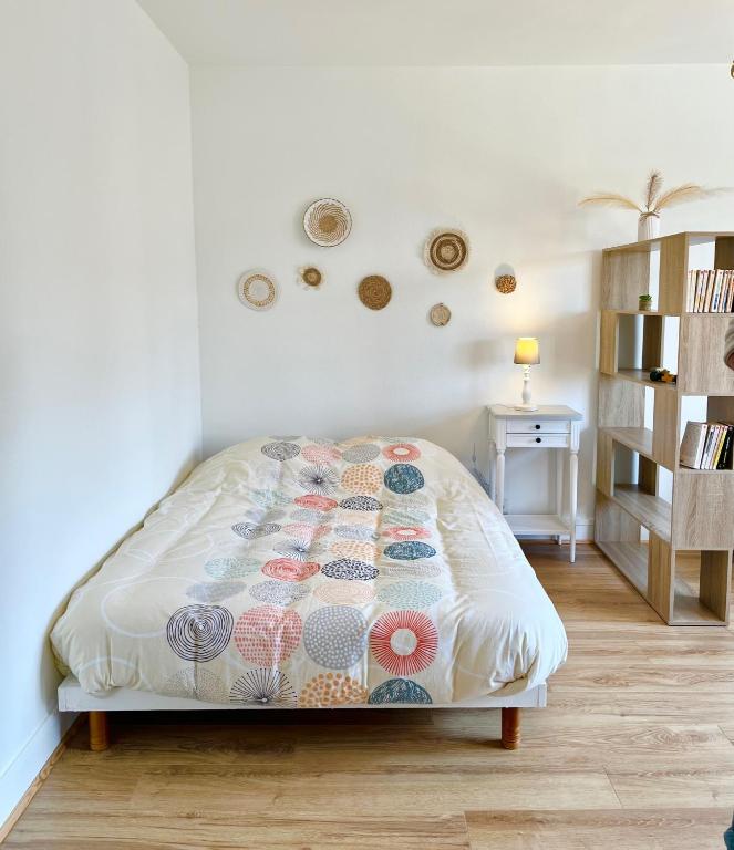 ein Schlafzimmer mit einem Bett mit einer Steppdecke darauf in der Unterkunft L'Hélios - T1 Bis - Bord de Sarthe in Le Mans