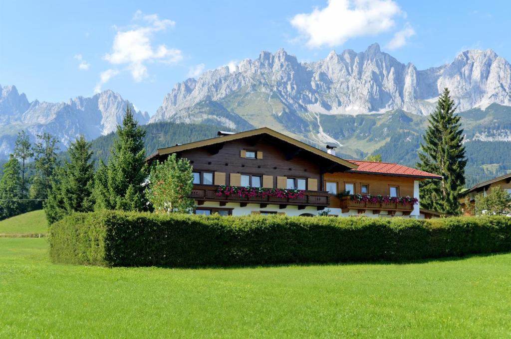 ゴイング・アム・ヴィルデン・カイザーにあるLandhaus Victoriaの山を背景にした畑の家