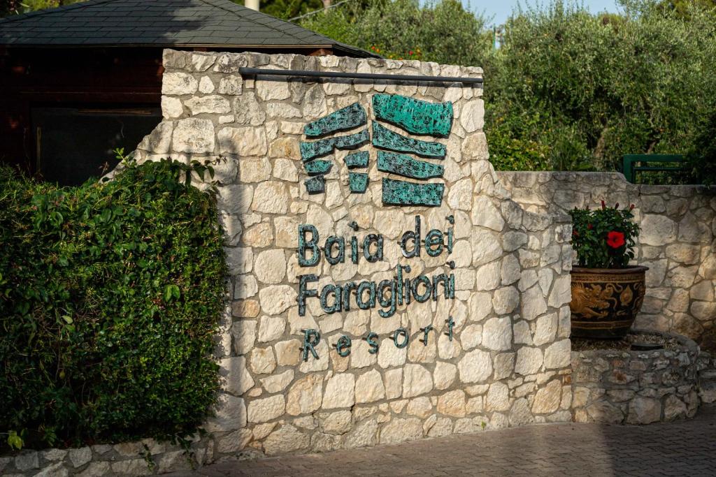a stone wall with a sign that reads before die emperor at AH Premium Baia dei Faraglioni in Mattinata
