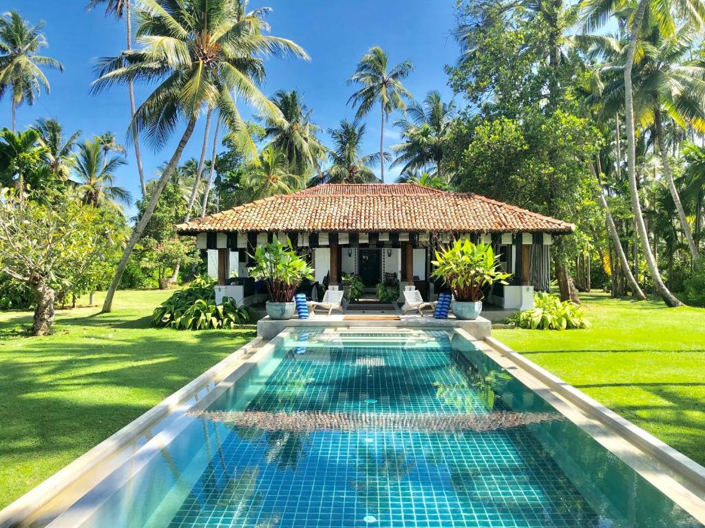 a villa with a swimming pool and a gazebo at Samaragiri in Talpe