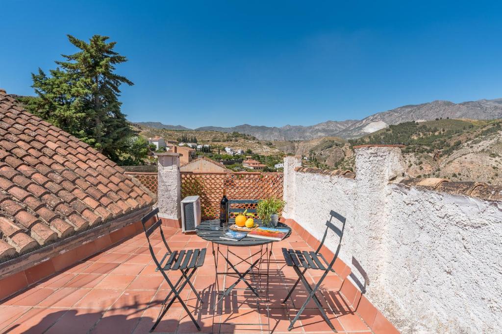 een terras met een tafel en stoelen op een dak bij Casa El Concejo in Cónchar
