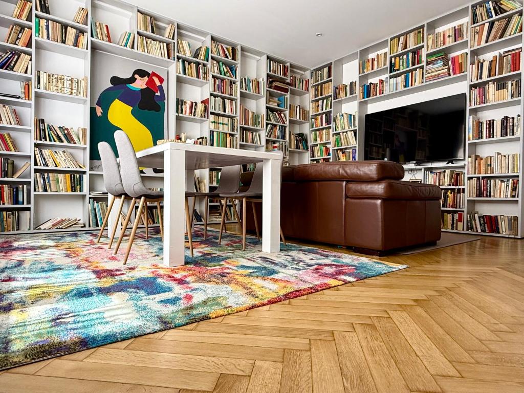 a room with a library with a table and chairs at Alexander library apartment in Košice