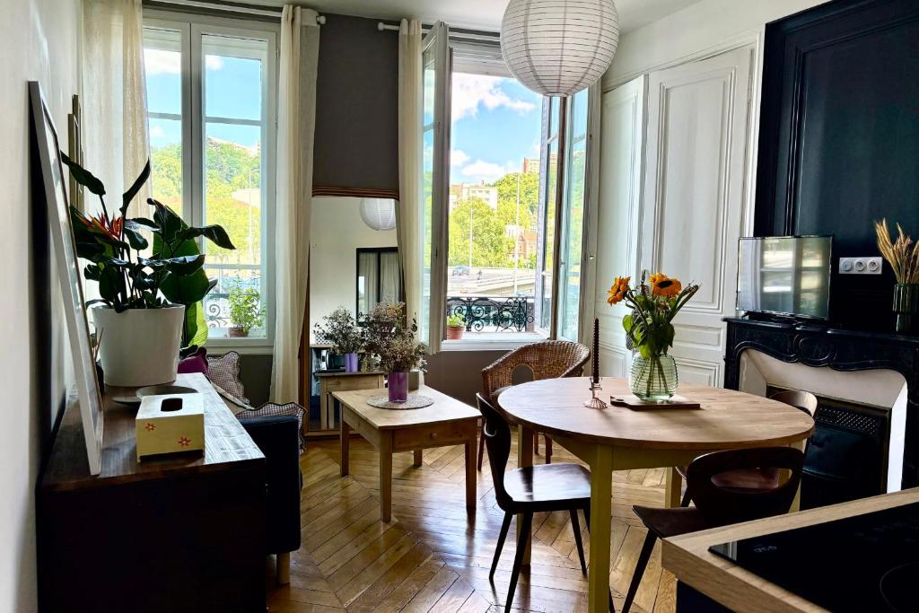 un salon avec une table et des chaises et une fenêtre dans l'établissement Charme et Caractère 10 min Bellecour, à Lyon