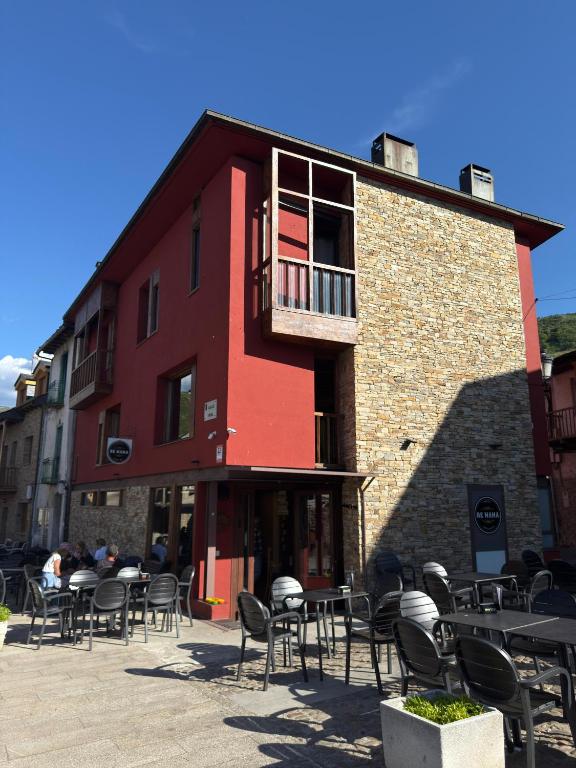 un edificio rosso con tavoli e sedie di fronte di De Mamá a Molinaseca