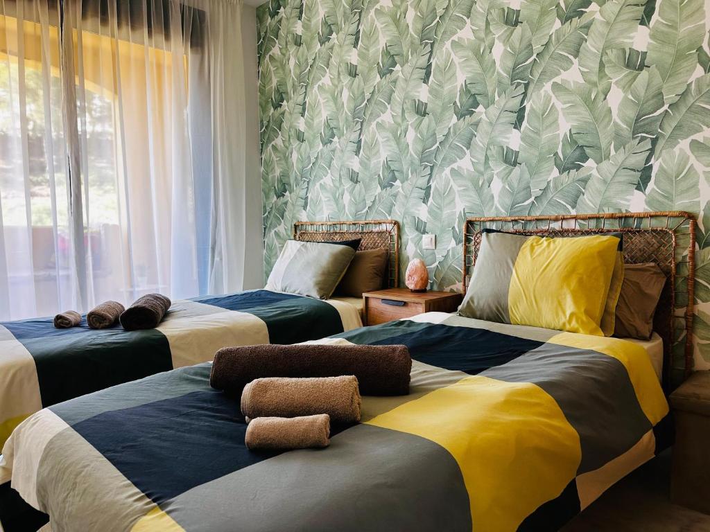 Un dormitorio con 2 camas y una pared con plantas. en Green Hill Apartment, en La Cala de Mijas