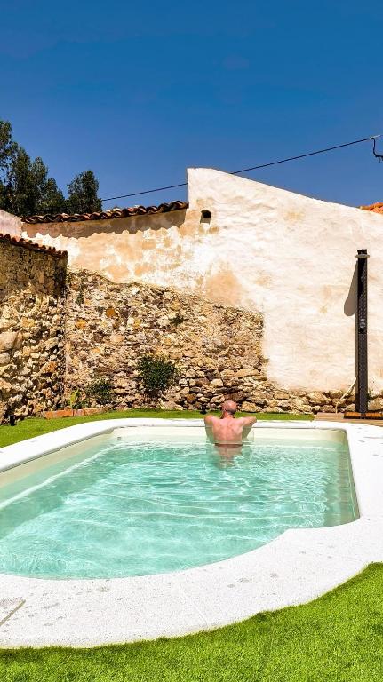 a swimming pool in front of a stone building at AMEIO - Country House in Rio Maior
