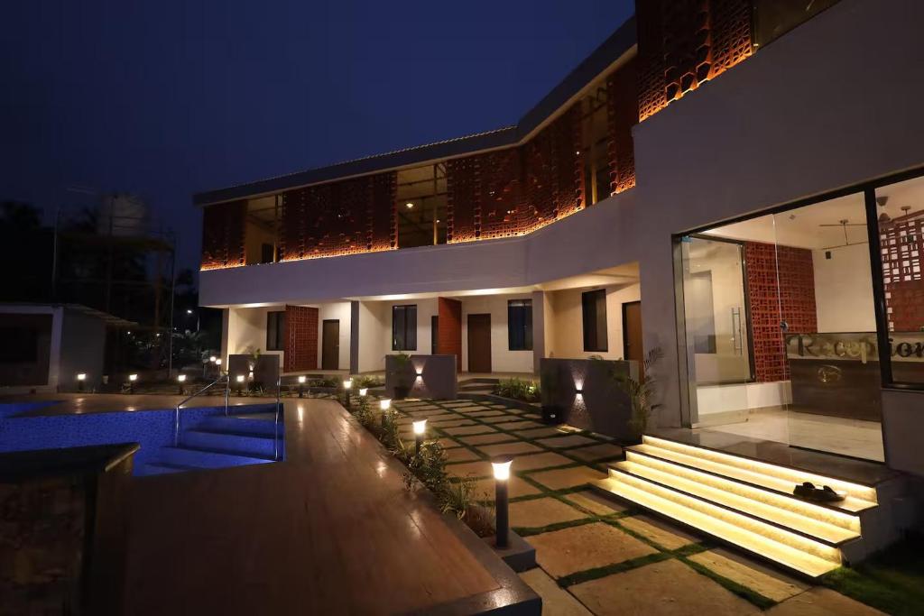 a house with a swimming pool at night at Blues Waves Resort in Alibaug