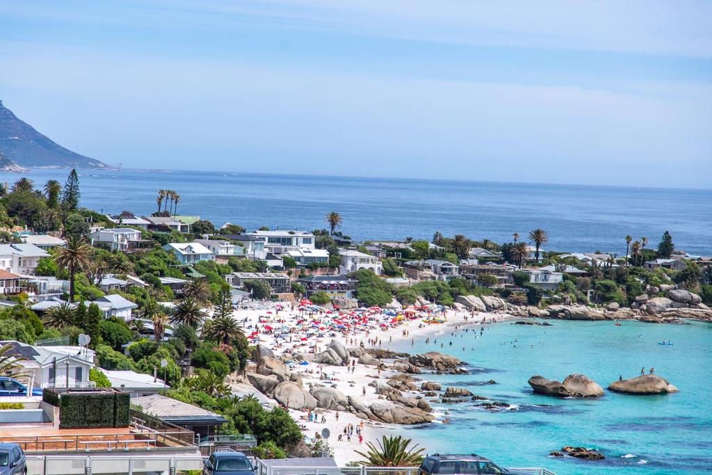 a beach with a crowd of people and the ocean at Clifton Studio - Seaviews & Walk To The Beach, Sea Point & Camps Bay in Cape Town