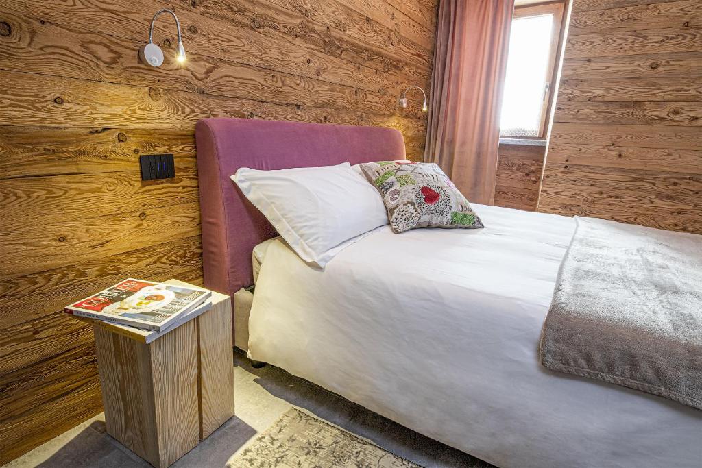 Un dormitorio con una cama y una mesa con un libro en Fenat, en Introd