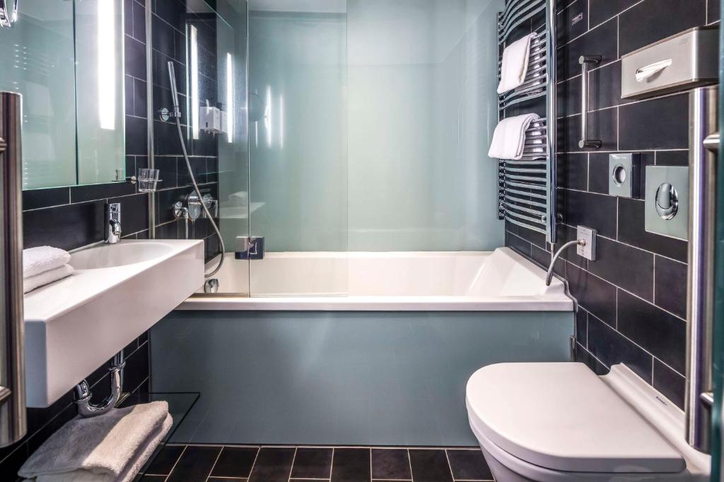 a bathroom with a tub and a toilet and a sink at Scandic Palace Hotel in Copenhagen