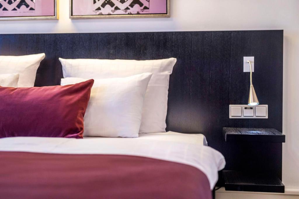 a bedroom with a bed with red and white pillows at Scandic Palace Hotel in Copenhagen