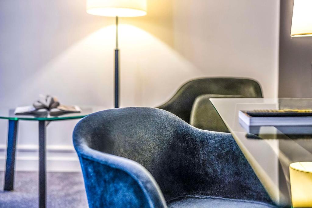 a room with chairs and a table with a lamp at Scandic Palace Hotel in Copenhagen