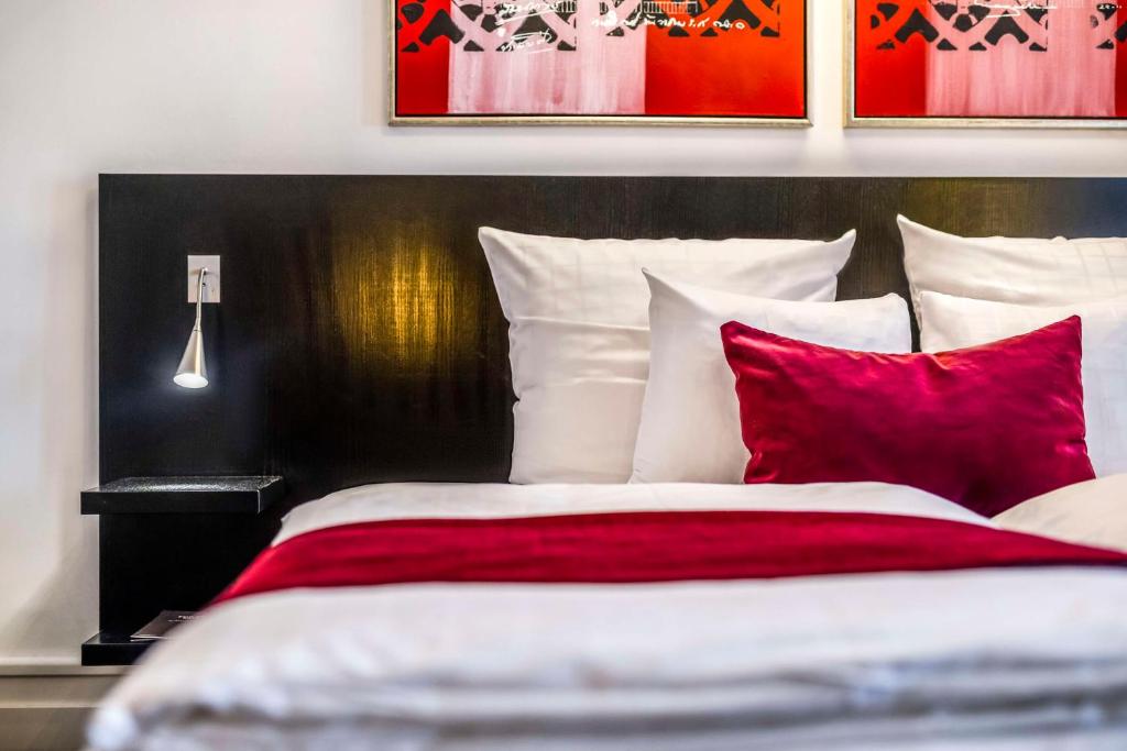 a bedroom with a bed with red and white pillows at Scandic Palace Hotel in Copenhagen