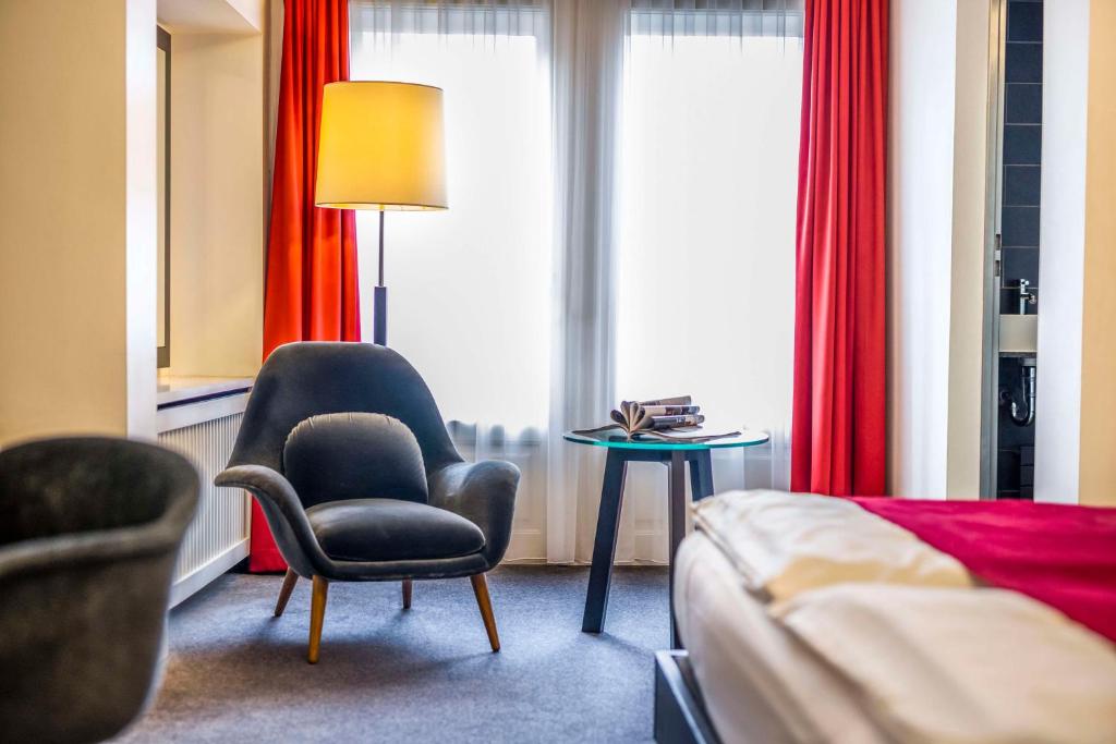 a hotel room with a bed and a chair and a table at Scandic Palace Hotel in Copenhagen