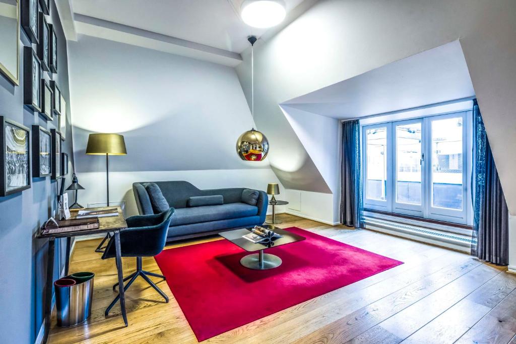 a living room with a couch and a red rug at Scandic Palace Hotel in Copenhagen